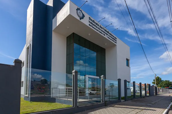Fachada de prédio comercial com fechamento externo de cerca em vidro temperado e placas de vidro laminado refletivo azul.