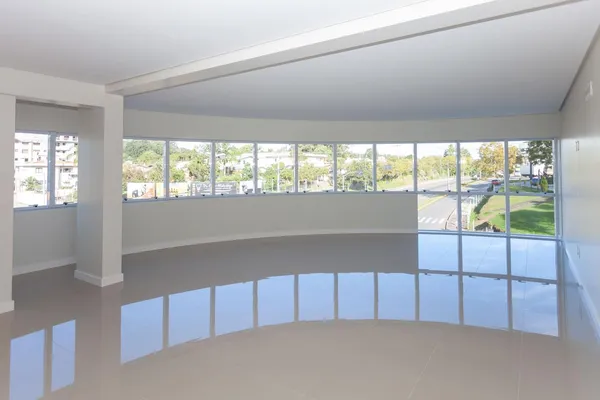 Fachada de edifício comercial exibindo esquadrias de alumínio e vidro laminado refletivo que controla a entrada de luz e calor.